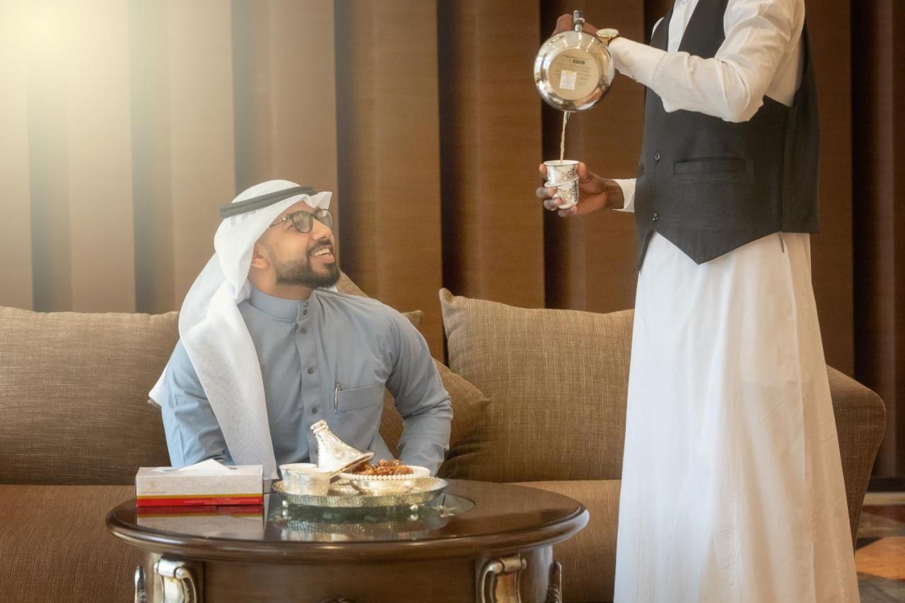 Al Safwah Orchid Hotel Mekka Buitenkant foto A man in traditional Arab dress being served coffee